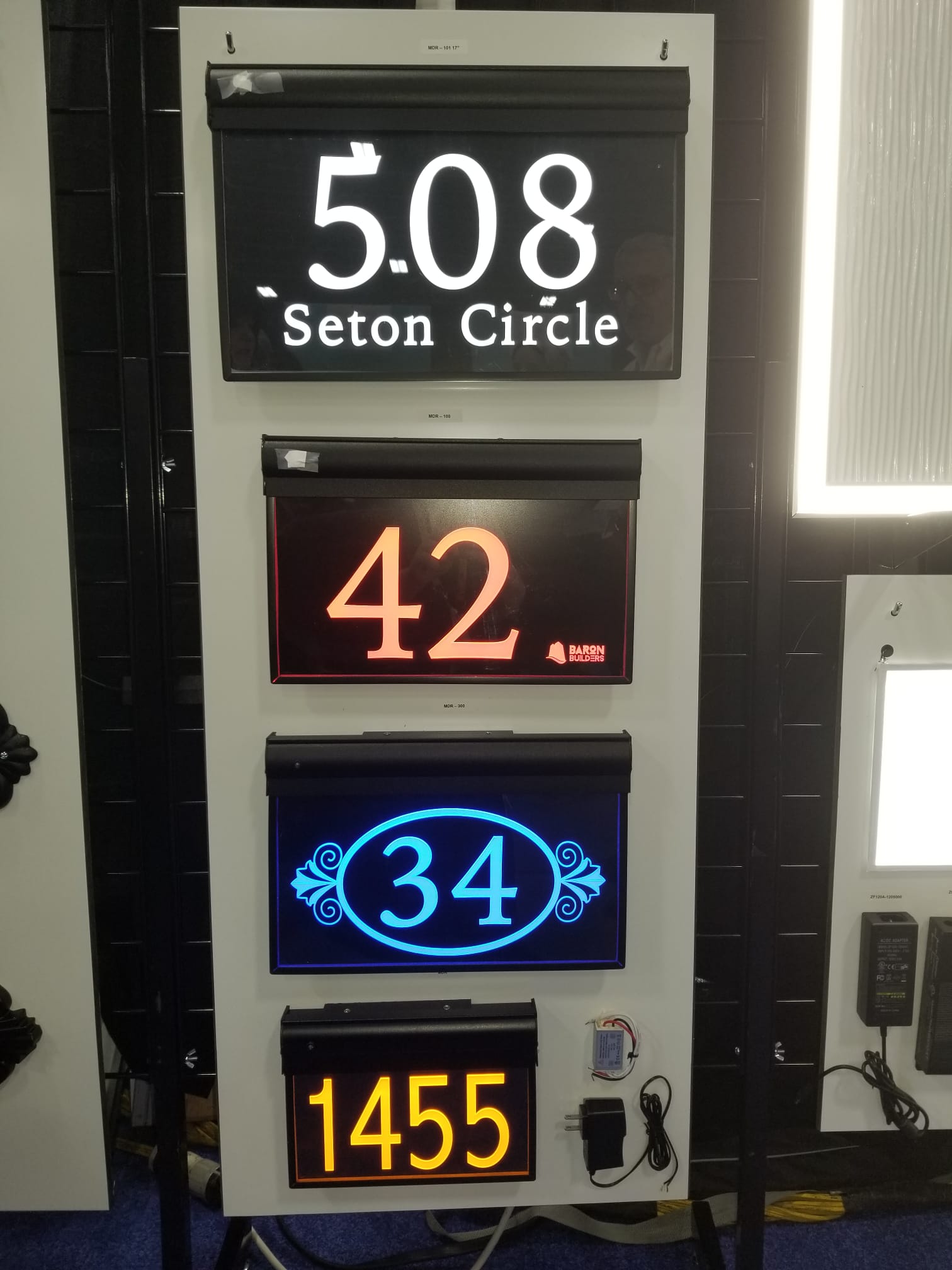 MDR series light-up address signs and lighted house numbers — white '508 Seton Circle', red '42', blue '34', and amber '1455' illuminated number signs